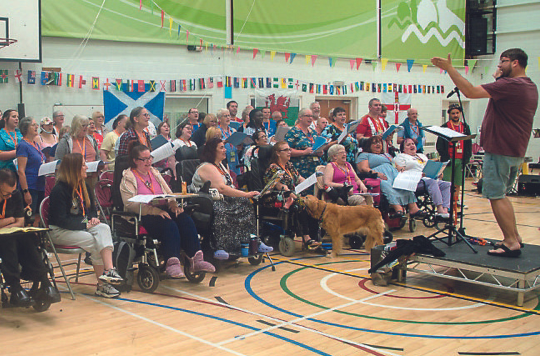 A group of people, some in wheelchairs, singing