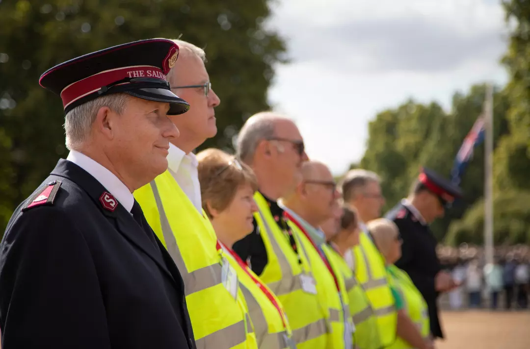 Uniformed Salvationists and volunteers in high visibility jackets standing in a line