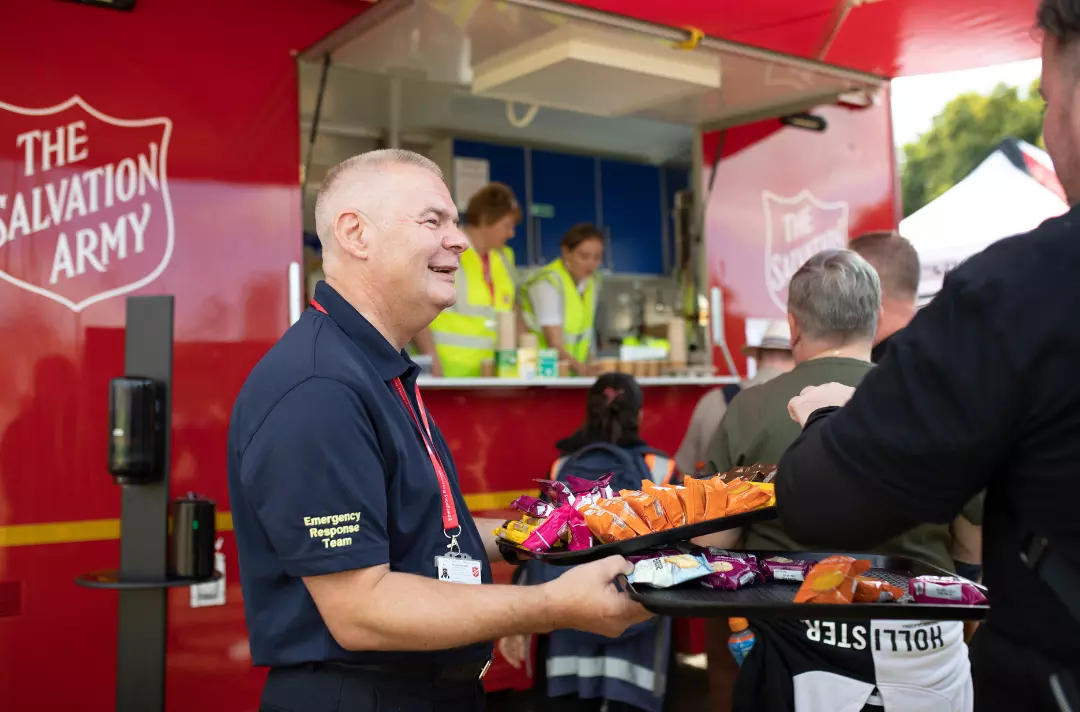 Salvation Army volunteer handing out biscuits