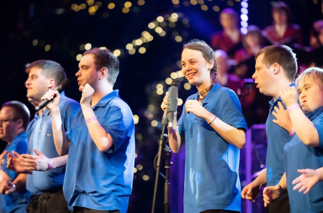 A photo the Music Man Project performing at the Royal Albert Hall holding microphones and singing