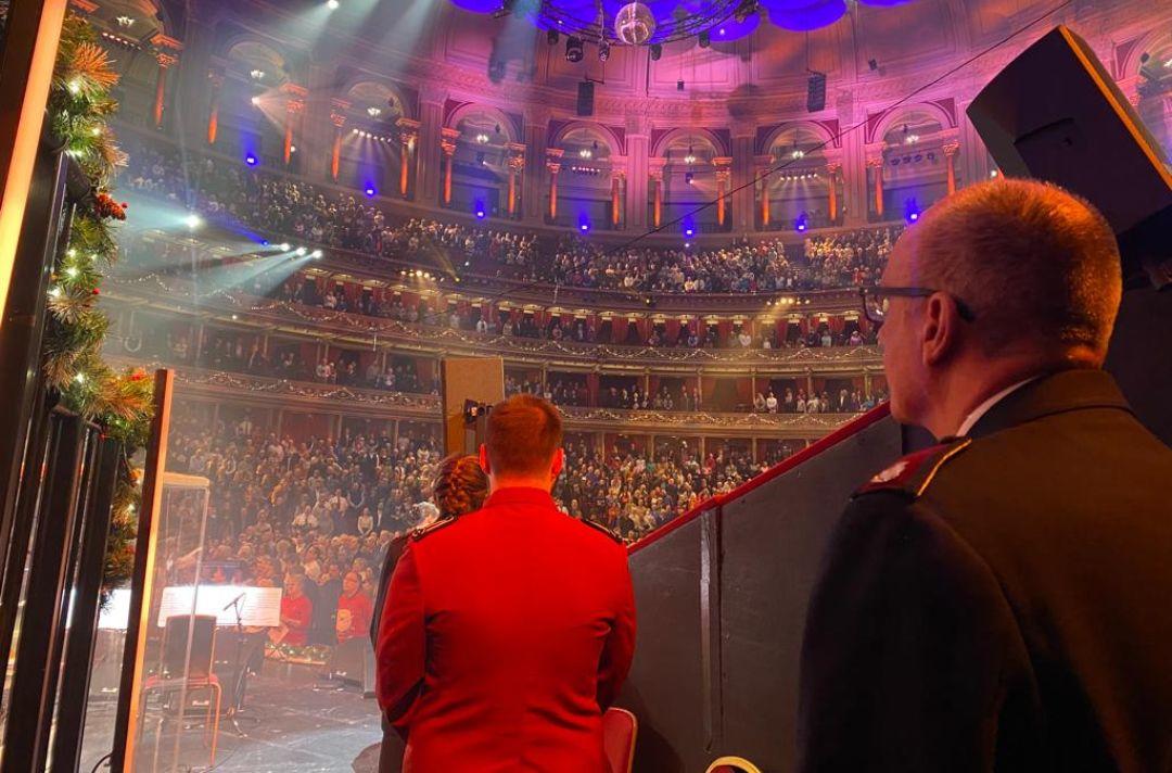 A photo in the wings of the Royal Albert Hall with Commissioner Anthony Cotterill looking out into the auditorium as the audience sings a carol