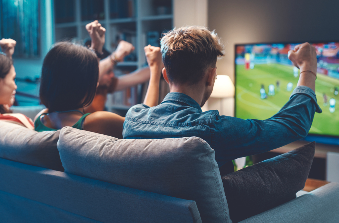 A photo of people watching a football game on TV