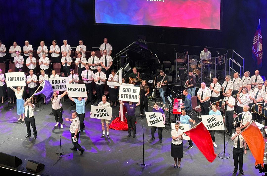 A photo of people waving flags on stage at Together 2024