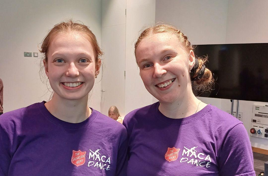 A photo of two young women in Maca Dance purple tops