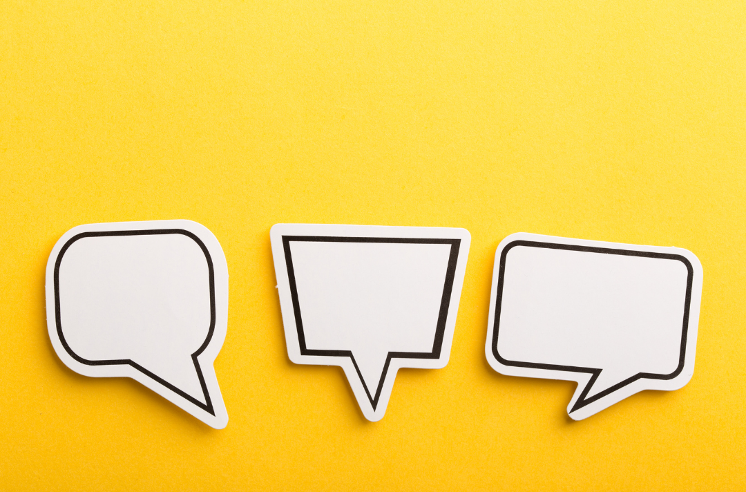 A photo shows three white paper speech bubbles against a yellow background.